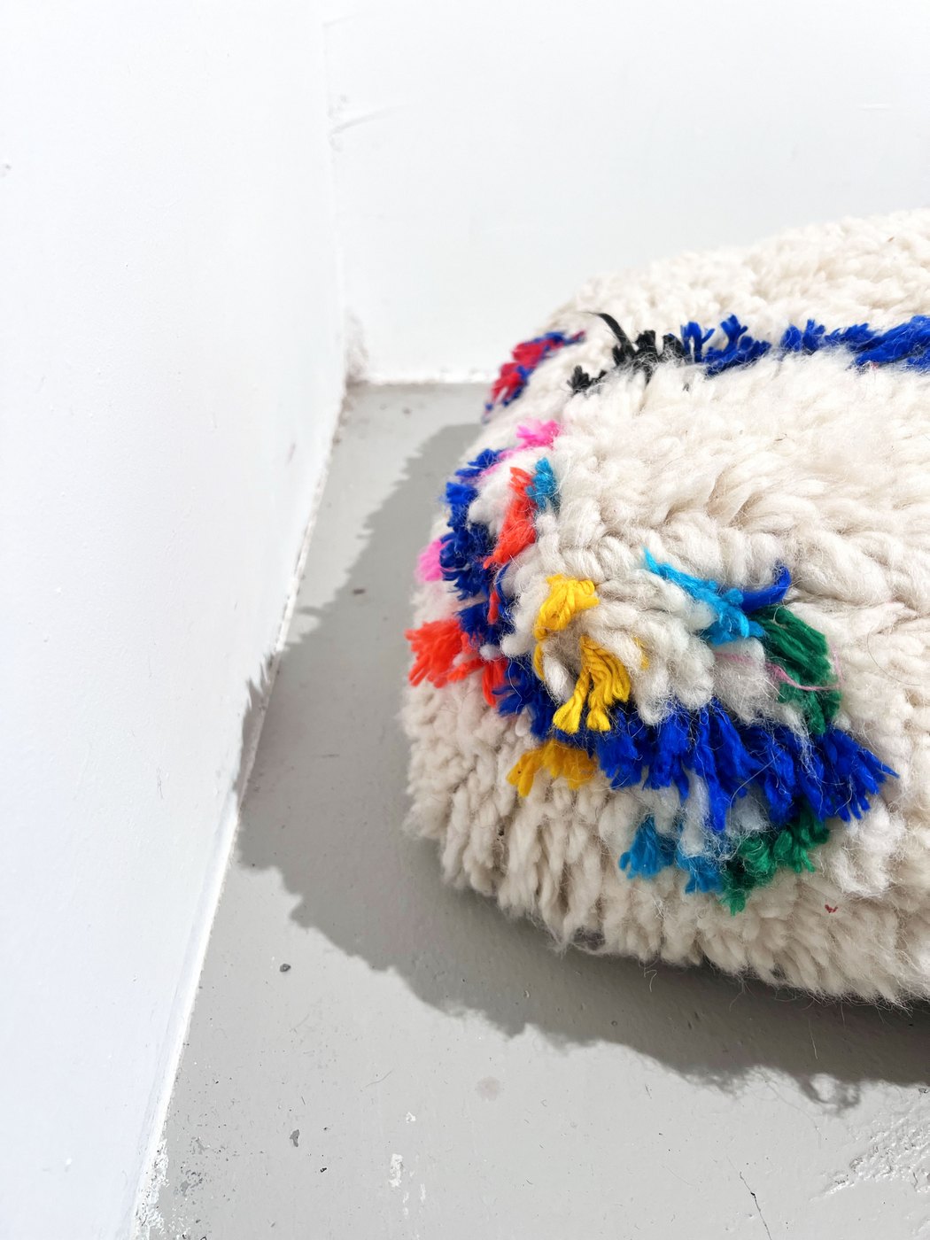 Puf bereber marroquí en crudo con motivos de colores