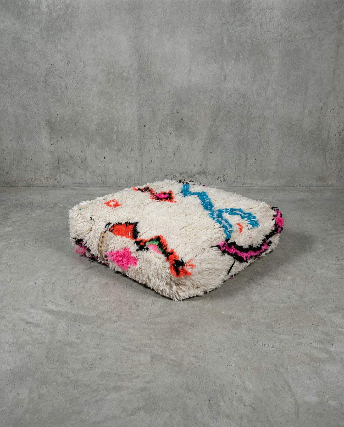 Puf bereber marroquí en crudo con motivos de colores
