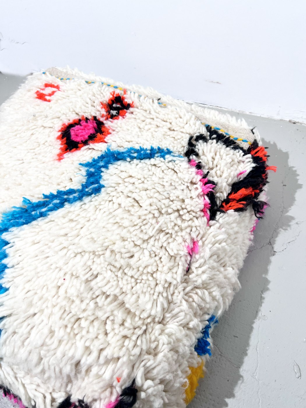 Puf bereber marroquí en crudo con motivos de colores