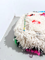 Puf bereber marroquí en crudo con motivos de colores