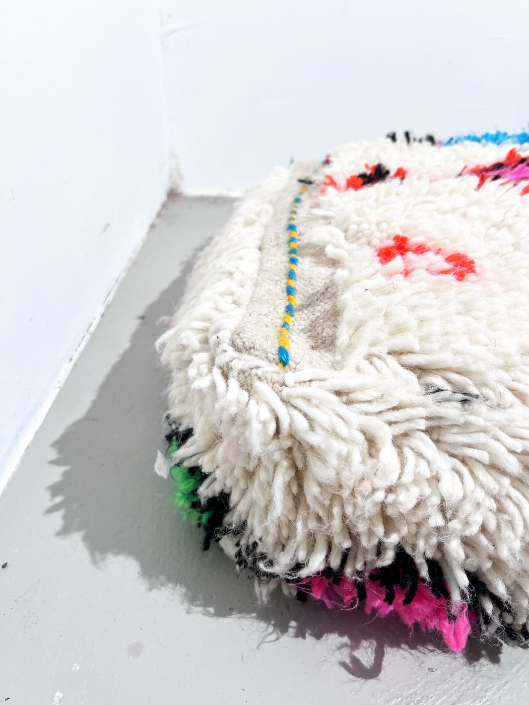 Puf bereber marroquí en crudo con motivos de colores