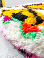 Puf bereber marroquí en crudo con motivos de colores