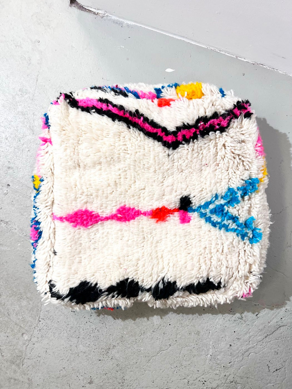Puf bereber marroquí en crudo con motivos de colores