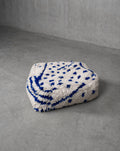 Puf bereber marroquí crudo con motivos azul Majorelle