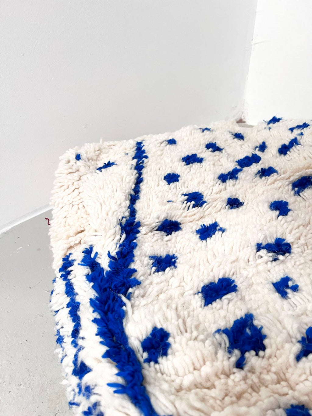 Puf bereber marroquí crudo con motivos azul Majorelle