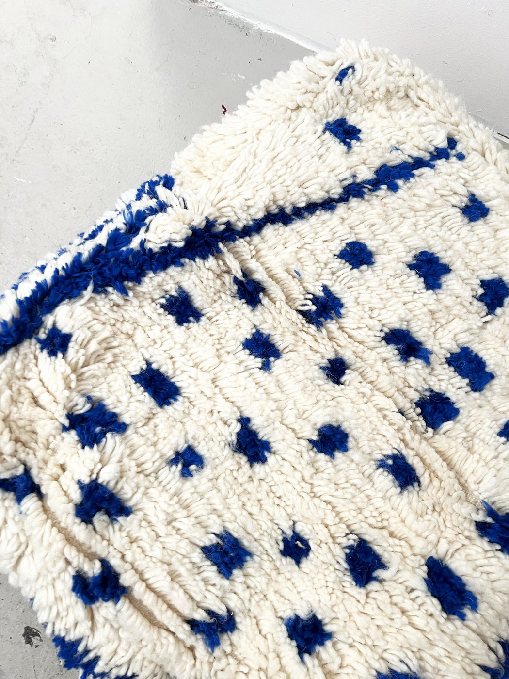 Puf bereber marroquí crudo con motivos azul Majorelle
