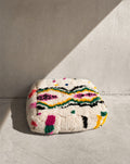 Puf bereber marroquí en crudo con motivos de colores