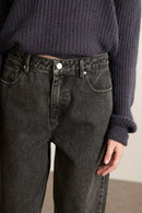 Fermeture par zip métallique et bouton, placés sur une ceinture droite avec passants larges et finitions renforcées.