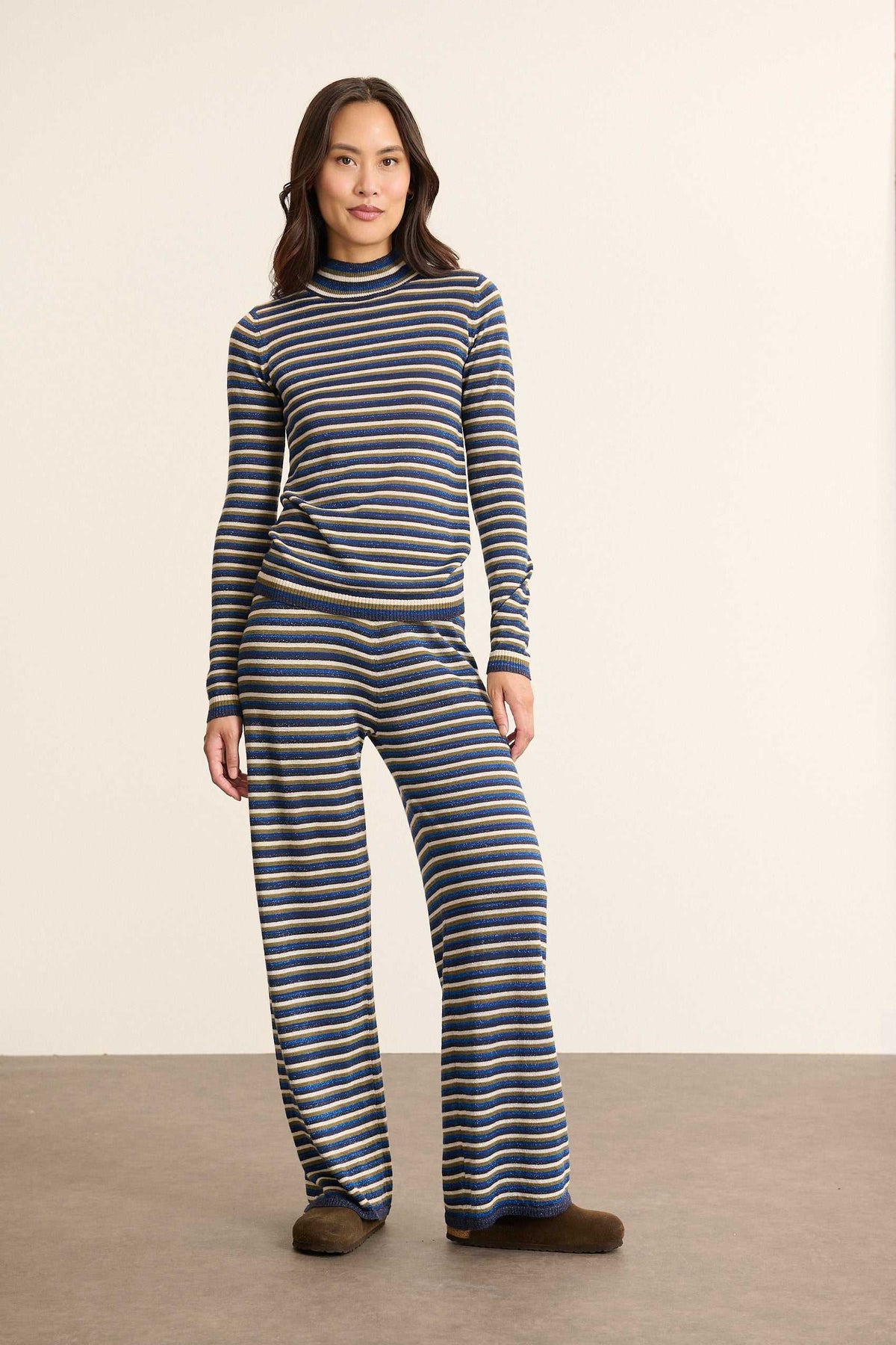 Mannequin femme de face portant un pantalon en maille bleu à rayures, coupe droite avec taille élastique et tombé souple.
