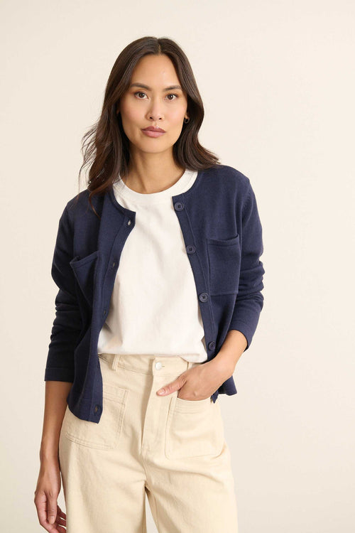 Mannequin femme de face portant un gilet marine à la coupe droite, col rond, poche poitrine plaquée et bouton effet corne.