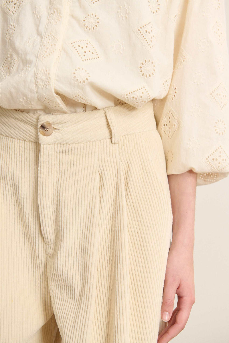 Pantalon à pinces en velours, fermeture par zip et bouton ton sur ton positionnés sur une ceinture plate avec passants.