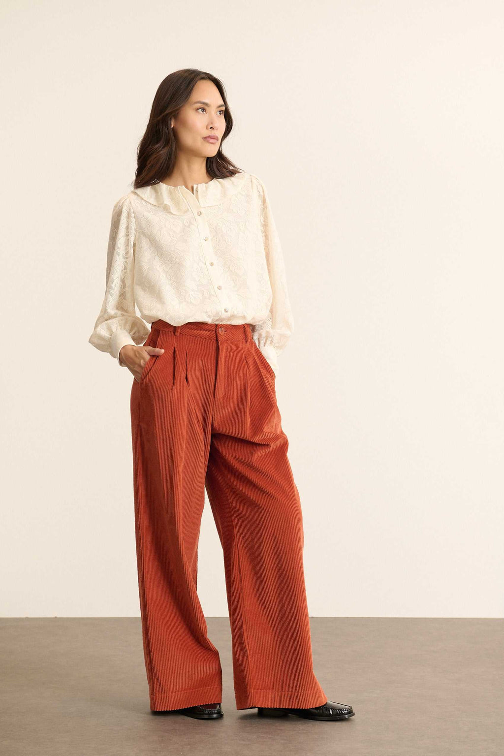 Pantalon à pinces en velours, fermeture par zip et bouton ton sur ton positionnés sur une ceinture plate avec passants.
