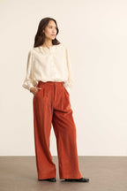 Pantalon à pinces en velours, fermeture par zip et bouton ton sur ton positionnés sur une ceinture plate avec passants.