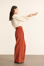 Pantalon à pinces en velours coloris terre cuite, collection Garance Paris automne hiver 2025, jambes larges et poches devant.