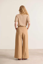 Pantalon pour femme de couleur beige contenant une touche sophistiquée apparente style plis à l'avant 