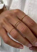 Close-up of a hand wearing gold rings on a white background