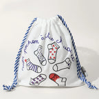 Pochon coton pour ranges ses Tites Chaussettes. Fond blanc, imprimé chaussettes à motifs bleu/rouge. Fermeture par lien coulissant blanc/bleu. 