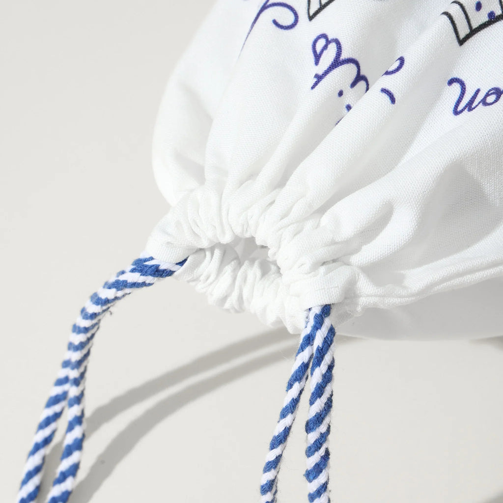Pochon coton pour ranges ses Tites Chaussettes. Fond blanc, imprimé chaussettes à motifs bleu/rouge. Fermeture par lien coulissant blanc/bleu. 