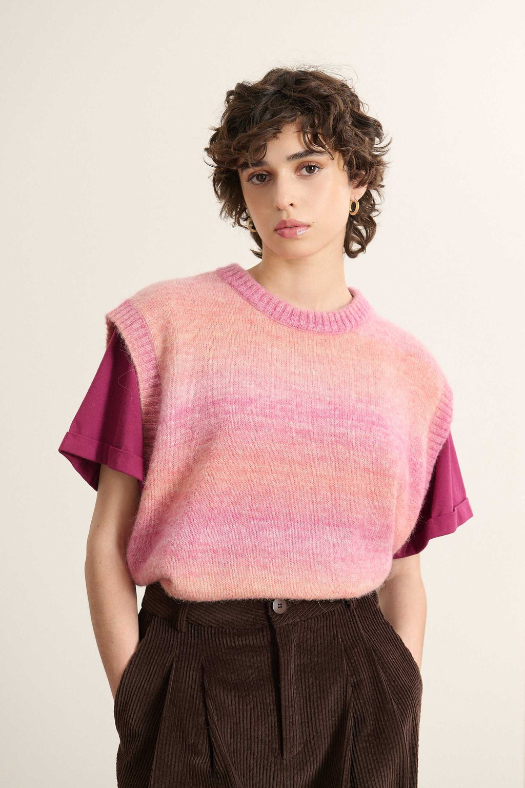 Mannequin femme de face portant un pull sans manches rose, coupe droite avec col rond, dégradé du rose clair au rose soutenu.