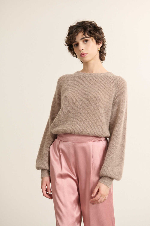 Mannequin femme de face portant un pull ample coloris taupe, col rond, emmanchure raglan et boutonnage dans le dos.