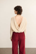 Vue arrière du pull beige, décolleté profond en V orné d’un nœud fixe et coupe droite légèrement ajustée.