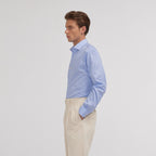 Hast – Blue Two-Ply End-on-End Shirt, male model wearing a blue shirt and beige trousers, side view