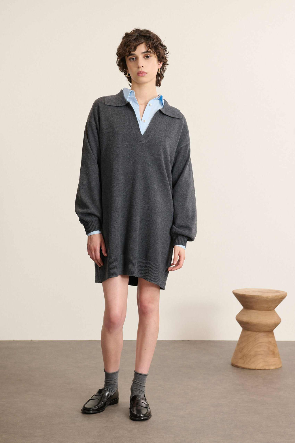 Mannequin femme de face portant une robe courte en maille gris clair, coupe droite avec manches longues et col polo.
