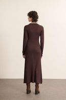 Vue arrière de la robe en maille marron, taille marquée et jupe longue évasée, couture centrale discrète.