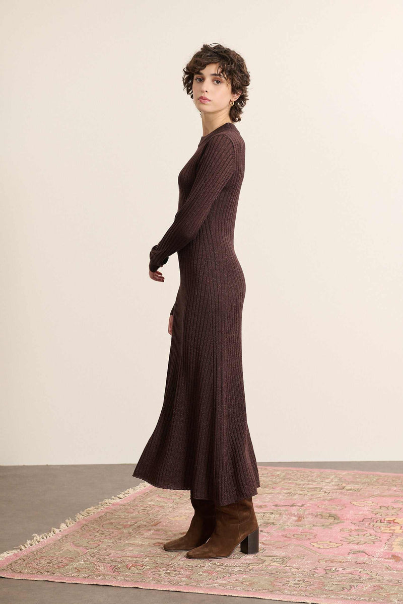 Vêtement pour femme, long, à manches longues ajustées coloris marine, en maille côtelée légèrement resserrée.