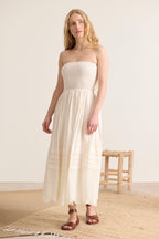 Broderie anglaise et plis délicats subliment cette robe écru smockée, doublée pour un confort absolu.