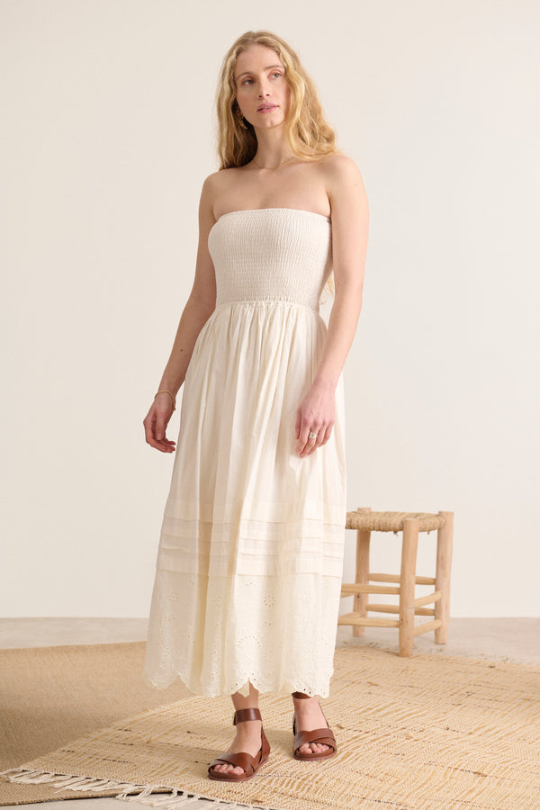Broderie anglaise et plis délicats subliment cette robe écru smockée, doublée pour un confort absolu.