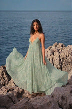 Vestido largo de gasa estampada verde, ligero y fluido, inspirado en los movimientos del mar. Corte vaporoso, silueta femenina y elegante: una pieza emblemática de Phème Paris.