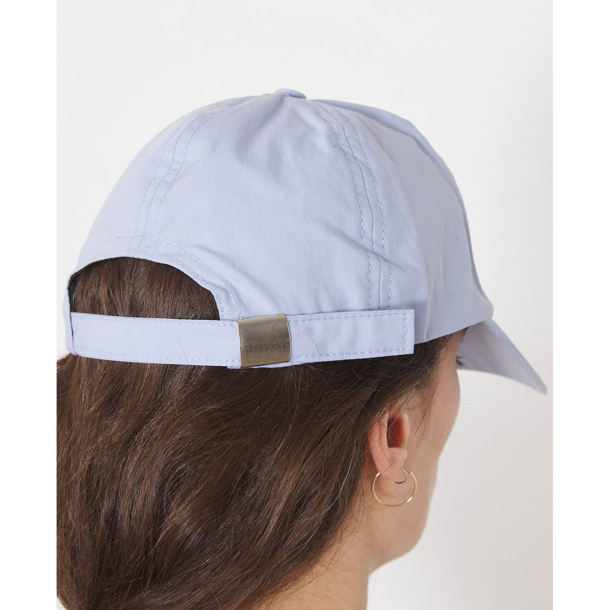Officine Générale – Casquette Baseball - Bleu Layette - Mixte, casquette bleu clair portée de dos par une femme aux cheveux bruns