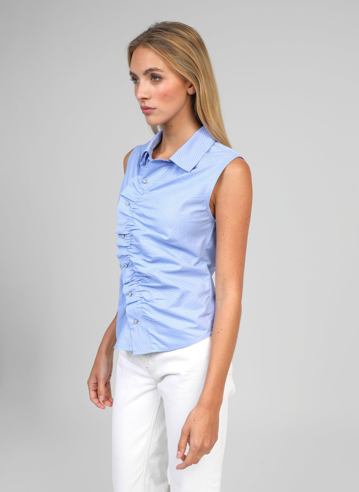 An'ge – Chemise Selyan Rayure, mannequin portant un chemisier bleu sans manches et un pantalon blanc
