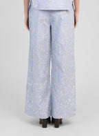 An'ge – Pantalon Ralya Rayure, pantalon large bleu clair brodé de motifs floraux blancs, porté de dos