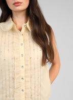 An'ge – Chemise Swany Jaune, haut sans manches crème avec des strass, porté par une femme