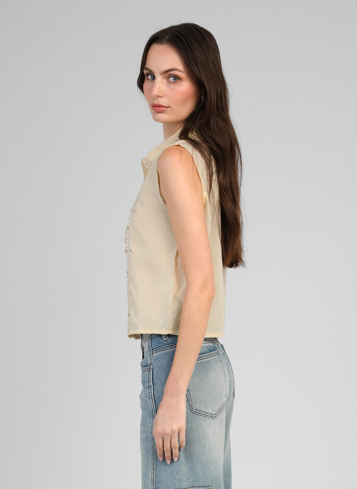 An'ge – Chemise Swany Jaune, mannequin portant un top beige sans manches et un jean bleu clair