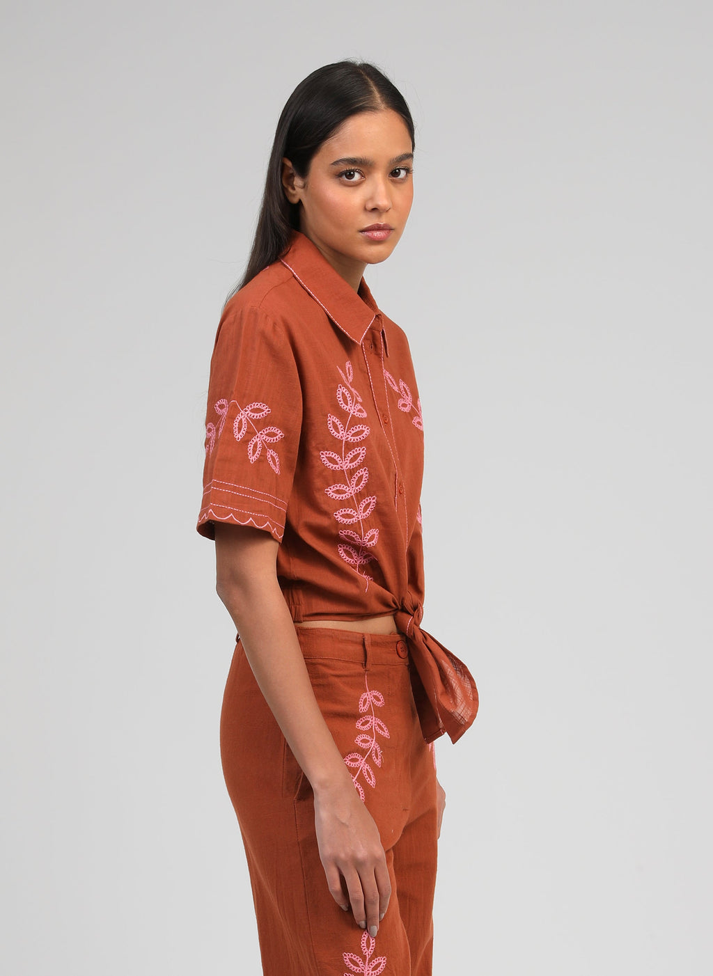 An'ge – Chemise Silona Caramel, mannequin portant une chemise courte et un pantalon marron brodés de motifs roses