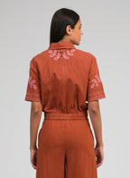 An'ge – Chemise Silona Caramel, mannequin de dos portant un ensemble marron avec broderies roses