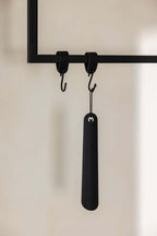 Schuhlöffel TILO in Schwarz an Haken, minimalist Design aus high-quality Metall.