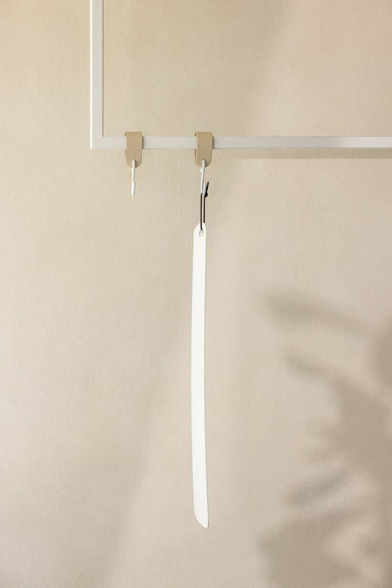 Minimalist Schuhlöffel TILO in high-quality metal, elegant in modern interior presentation.