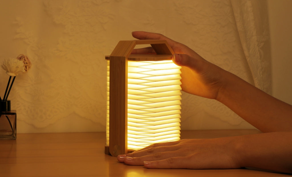 Gingko Design – Lampa Smart Origami - Naturalny Bambus, składana lampa z jasnego drewna i papieru, stojąca na drewnianym stole