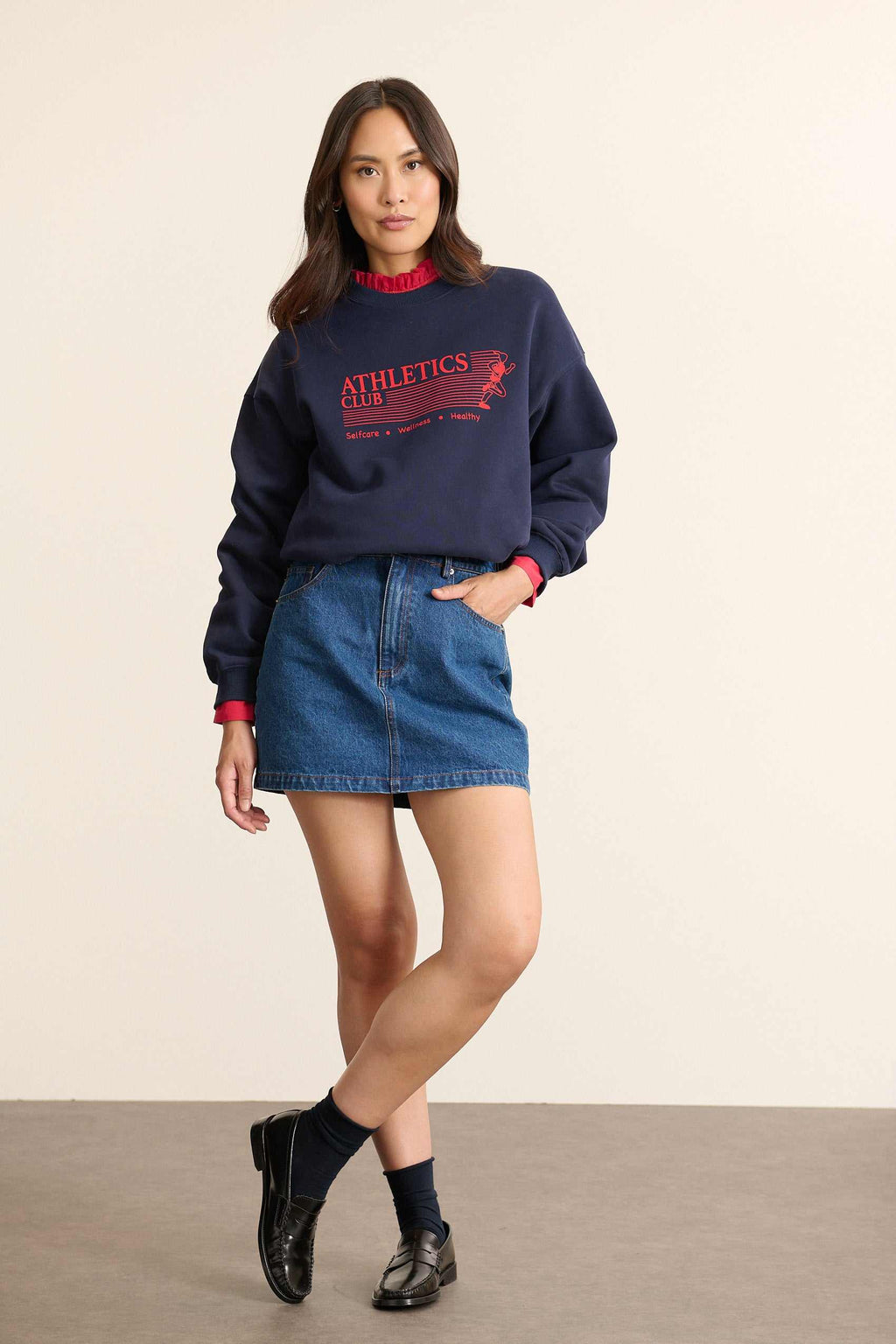 Mannequin femme de face portant un sweat ample coloris marine, col rond, manches longues et imprimé sur le devant.