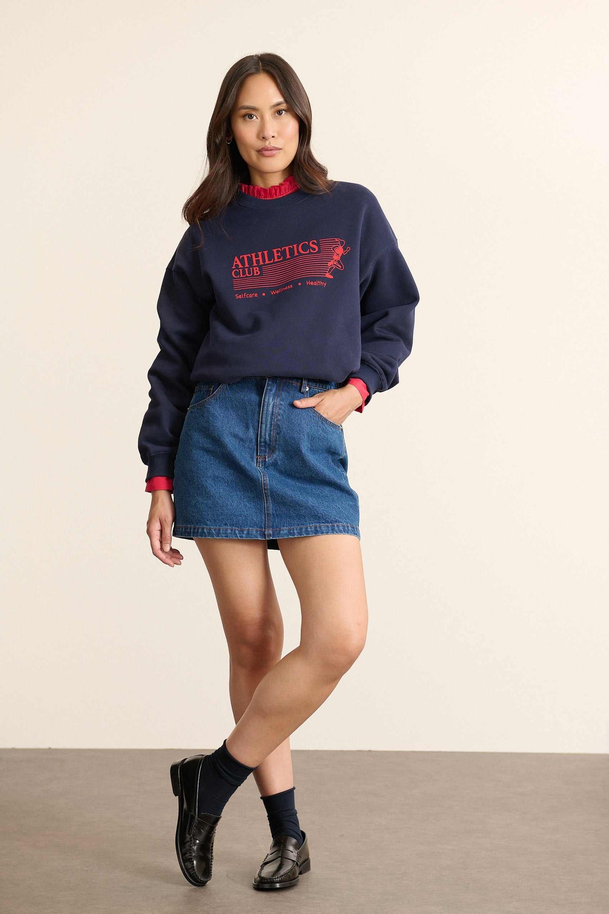 Mannequin femme de face portant un sweat ample coloris marine, col rond, manches longues et imprimé sur le devant.
