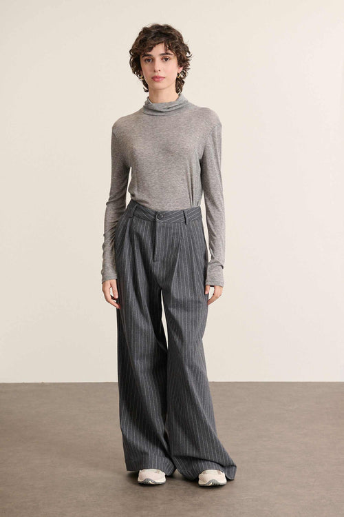 Mannequin femme de face portant un sous-pull gris à col montant, coupe ajustée et manches longues en maille fine. 