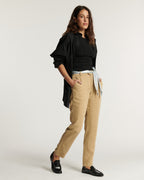 Pantalon en tissu Tencel couleur praline, coupe droite et ajustée, ceinturé à la taille pour un confort et une élégance naturelle adaptés à toutes les morphologies.