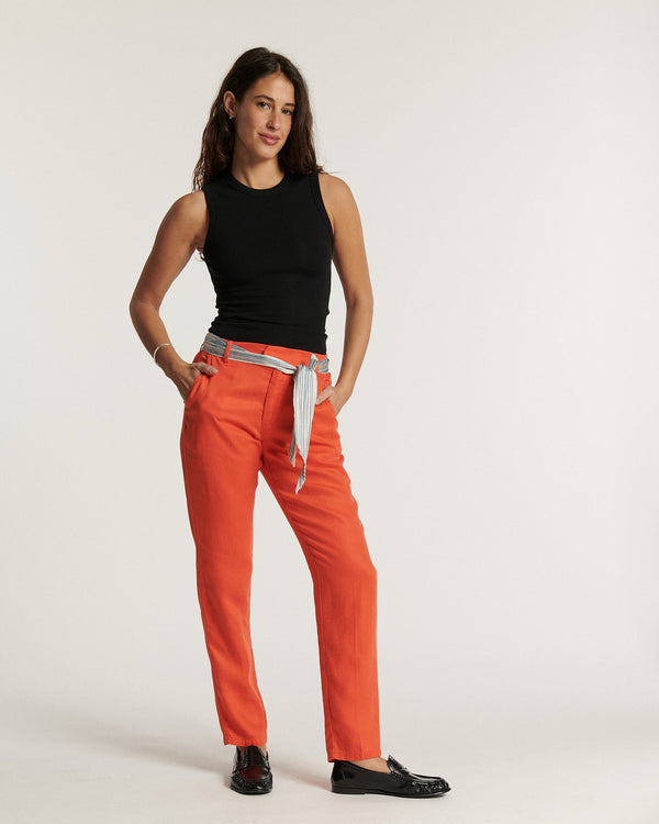 Trousers in soft orange tencel fabric with straight cut suitable for all body shapes, matching striped belt, feminine and comfortable style.