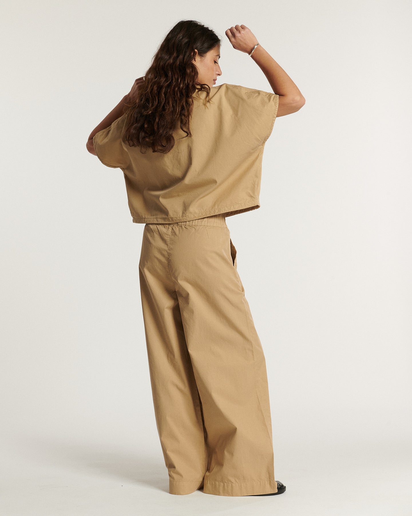 Pantalon large en popeline coloris praline, léger et fluide, coupe ample parfaite pour épouser toutes les morphologies féminines avec élégance et confort.