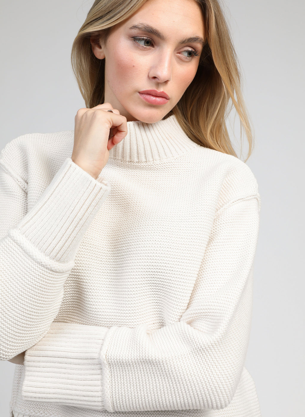 An'ge – Pull Valora Ecru, mannequin portant un pull en maille crème à col montant, vue rapprochée