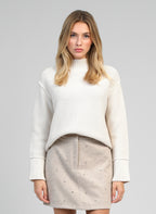 An'ge – Pull Valora Ecru, mannequin femme portant un pull blanc et une jupe beige cloutée, vue de face